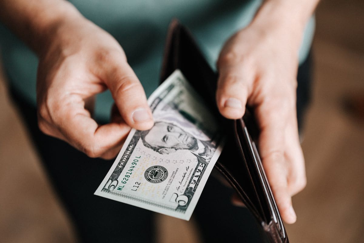 Person holding a wallet with money