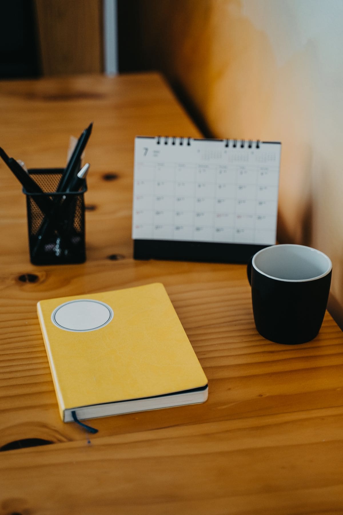 Notebook, calendar and mug on a wooden table