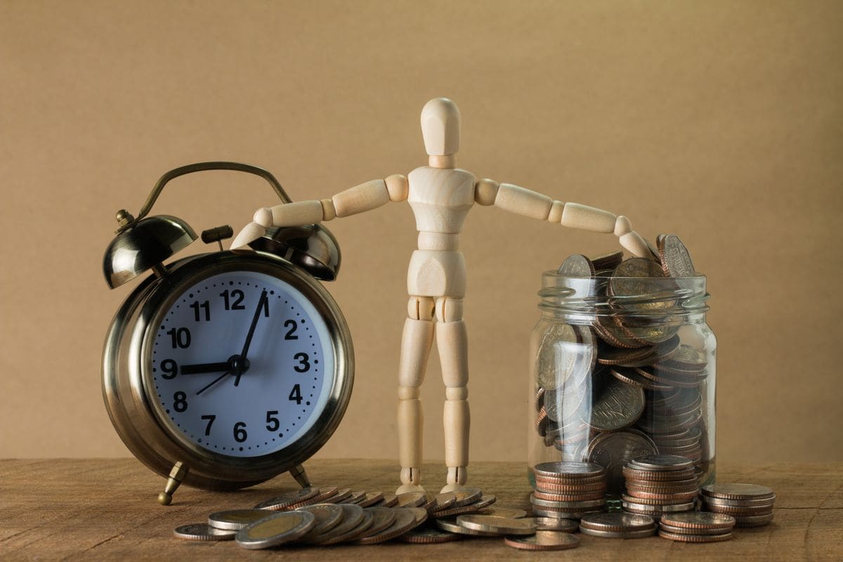 Jar of coins beside an alarm clock