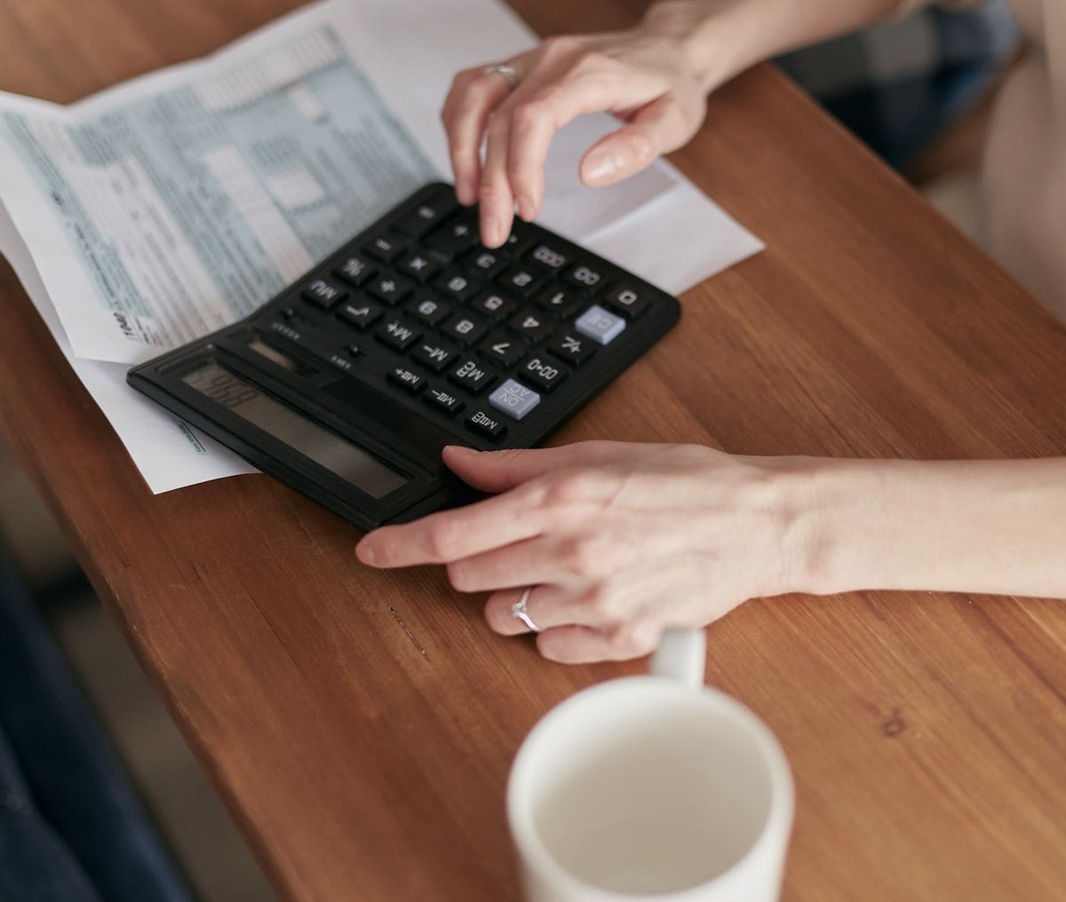 Woman using a calculator for budget planning at home